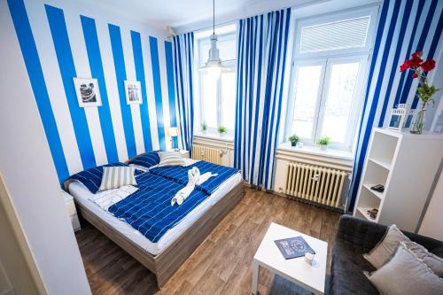 - une chambre avec des murs rayés bleus et blancs et un lit dans l'établissement Apartmány Lanna, à České Budějovice