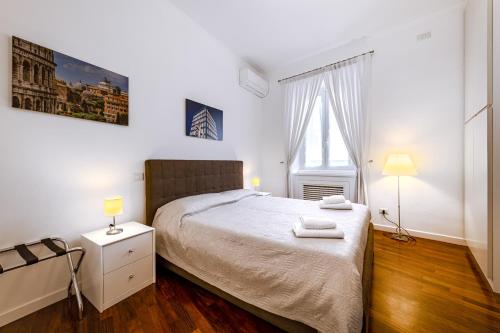 a bedroom with a bed with white sheets and a window at Saint Peter House Station in Rome