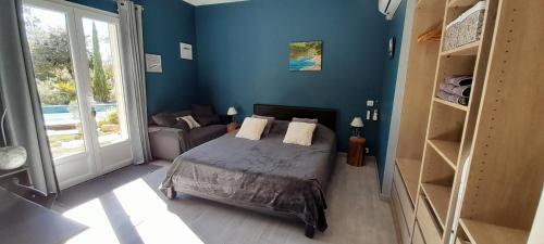 1 dormitorio con paredes azules y 1 cama con almohadas en La Villa Provençale, en Lorgues