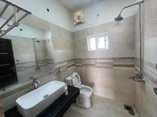 a bathroom with a tub and a toilet and a sink at Haven Lodge, Family Suite with Lounge & Kitchen in Islamabad