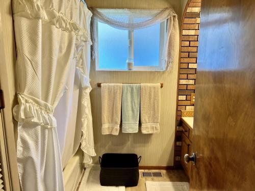 a bathroom with towels and a window and a shower at Leah's Homestay in Hoquiam in Hoquiam