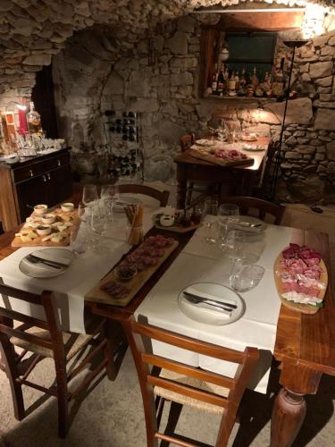 a table with plates and glasses on top of it at Bed & Breakfast Casa Marinella in Lenna