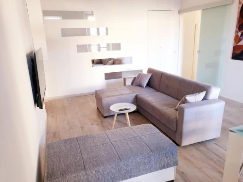 sala de estar con sofá y mesa en Your Spacious & Lovely home -2 queen bed, 2 large single beds-, en Milán