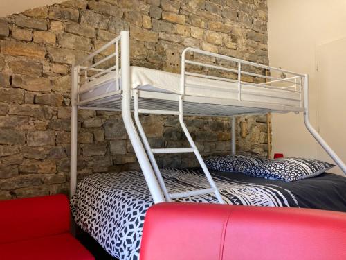 Łóżko piętrowe w pokoju z ceglaną ścianą w obiekcie La Chambre du Tonneau w mieście Montigny-sur-lʼAin