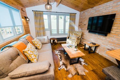 a living room with a couch and a tv at Low Moor Lodge in Scarborough