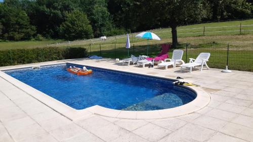 a swimming pool with people in a raft in it at Gites Le Clos de Lamie avec 2 piscines privées in Fossemagne