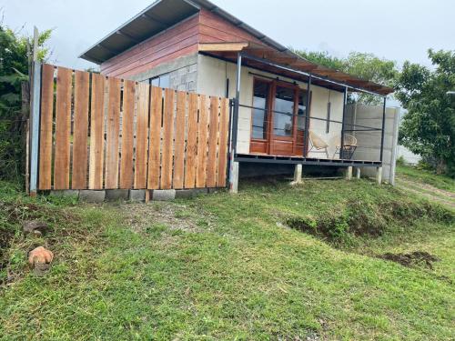 een klein huis op een heuvel met een hek bij Hostel La Suerte in Monteverde Costa Rica