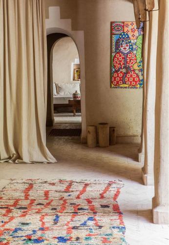 a hallway with a rug and a painting on the wall at Dar Zahia in Taroudant