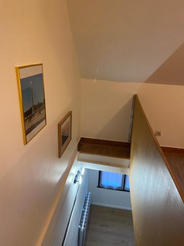 an attic room with a staircase and a mirror at Le Bassam, proche aéroport in Tillé