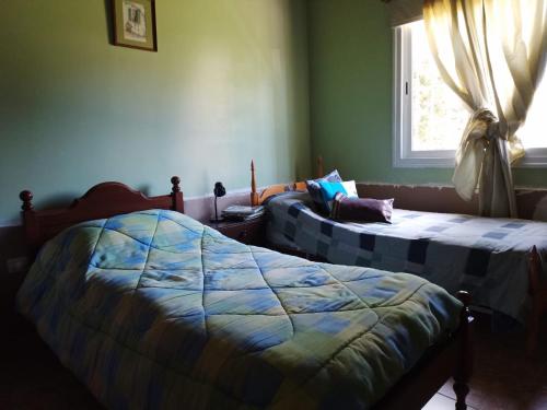 1 dormitorio con 2 camas y ventana en Casa en Barrios Los Arcos en Plottier