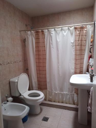 a bathroom with a toilet and a sink at Casa en Barrios Los Arcos in Plottier