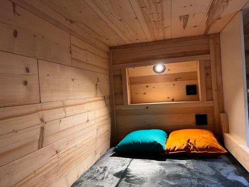 a small bed in a room with wooden walls at Les appartements de Makalu Val Thorens in Val Thorens