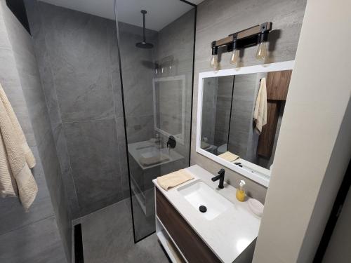 y baño con lavabo, espejo y ducha. en Miraflores Rentals LarcoMar, en Lima