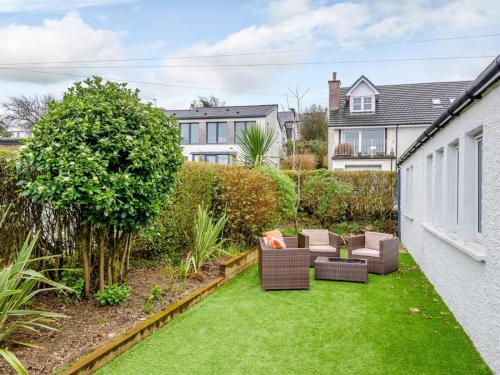 a garden with furniture and grass in a house at Cosy 3 bedroom home in centre of Brodick in Brodick