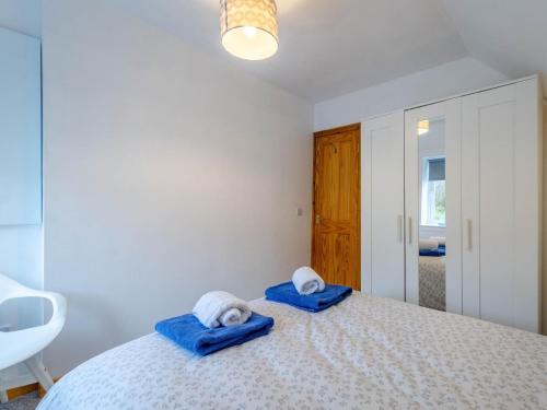 a bedroom with a bed with blue towels on it at Cosy 3 bedroom home in centre of Brodick in Brodick