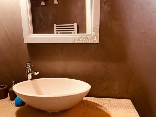 a bathroom with a bowl sink and a mirror at VILLA SANTONI in Porticcio