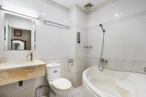 a bathroom with a toilet and a tub and a sink at Queen Hotel Airport in Ho Chi Minh City