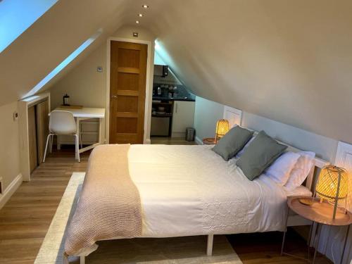 a bedroom with a large white bed in a attic at The Little Gable in Wavendon