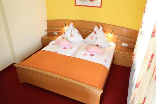 a small bedroom with a bed with two pillows at Enzianbrenner in Jenig