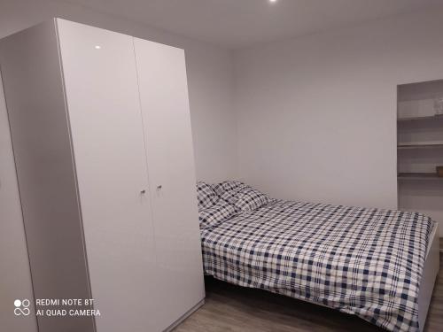 - une petite chambre avec un lit et un placard dans l'établissement Joli studio au centre d'Uriage, à Vaulnaveys-le-Haut