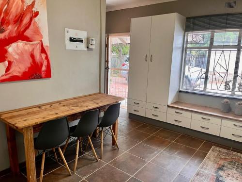 a kitchen with a wooden table and chairs at Lielies Guesthouse in Parys