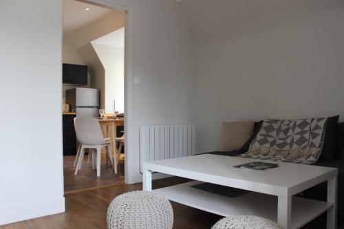 ein Wohnzimmer mit einem weißen Tisch und 2 Stühlen in der Unterkunft Intra-Muros - T2 La Grande Hermine in Saint-Malo