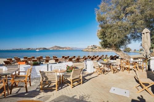 a group of tables and chairs next to the water at Kalergis Studios in Naxos Chora