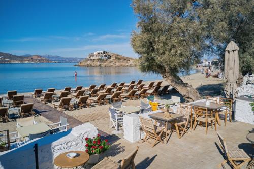 a beach area with tables, chairs and umbrellas at Kalergis Studios in Naxos Chora
