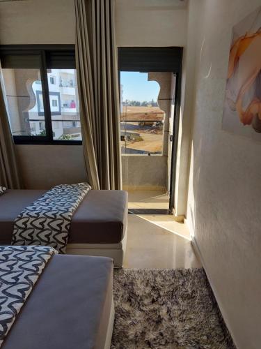 een kamer met 2 bedden en een raam met uitzicht bij B&B DELUXE COMFORT in Fès