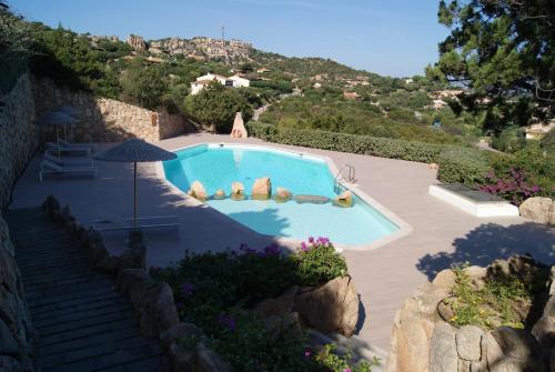 een zwembad in een tuin met een heuvel bij Case Della Marina in Porto Cervo
