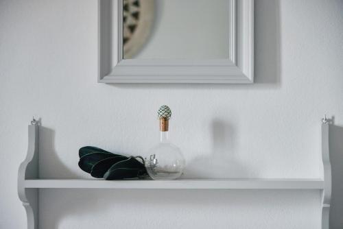 a glass vase sitting on a shelf under a mirror at Kalergis Studios in Naxos Chora