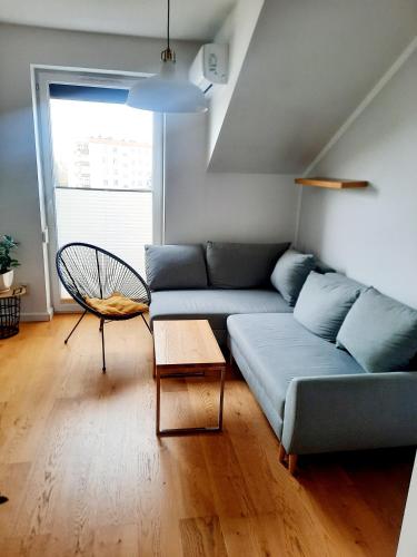 ein Wohnzimmer mit einem blauen Sofa und einem Tisch in der Unterkunft Apartament 252 in Kielce