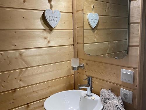 a bathroom with a sink and a mirror with hearts on the wall at Le Paradis de Verdure in Natzwiller
