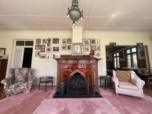 a living room with a fireplace and portraits on the wall at Estancia Río Penitente in Villa Tehuelche 