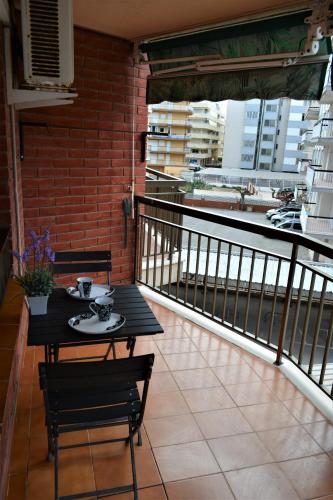 a table and chairs on a balcony with a view at Apartamento Piñol - Playa de la Pineda in La Pineda