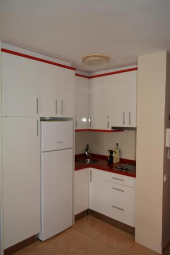 a kitchen with white cabinets and a sink at Apartamento Piñol - Playa de la Pineda in La Pineda