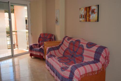 a living room with a couch and a chair at Apartamento Piñol - Playa de la Pineda in La Pineda