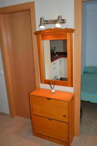 a wooden dresser with a mirror on top of it at Apartamento Piñol - Playa de la Pineda in La Pineda