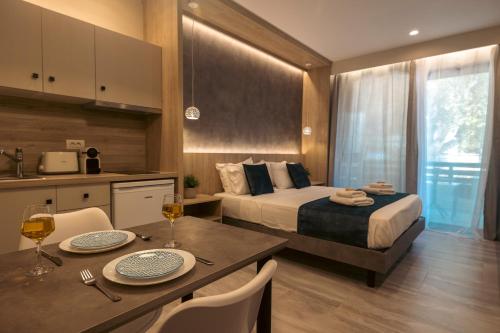 a hotel room with a bed and a table with chairs at Nicole Studios in Ayia Evfimia