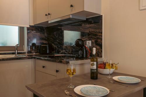 een keuken met een tafel met twee glazen wijn bij Nicole Studios in Ayia Evfimia