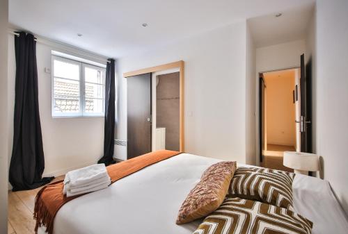 sypialnia z dużym białym łóżkiem i oknem w obiekcie 02#Duplex 2Bedrooms#Sèvres Lecourbe#Necker w Paryżu
