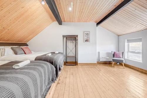 a bedroom with two beds and a wooden ceiling at Spacious Home - Ideal for Contractors in Northampton