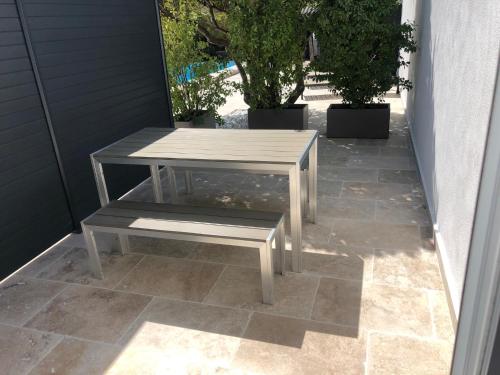a picnic table and bench on a patio at L'arbousier in Cassis