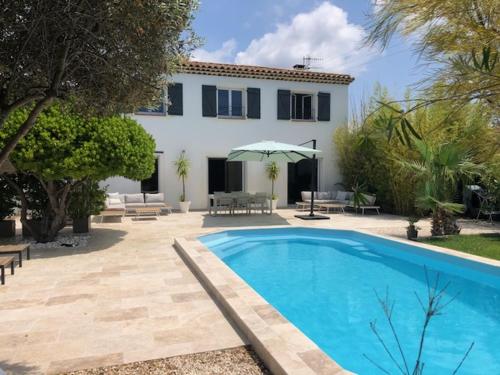 a swimming pool in front of a house at L'arbousier in Cassis