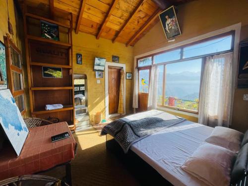 1 dormitorio con cama y ventana grande en Neer Stays en Munsyari