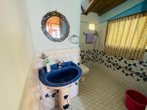 y baño con lavabo azul y aseo. en Neer Stays en Munsyari