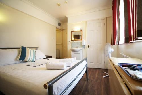 a bedroom with a large bed and a bathroom at Flexistay Norbury Aparthotel in London