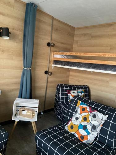 ein kleines Zimmer mit einem Sofa und Etagenbetten in der Unterkunft Studio cosy 5 personnes aux pieds des pistes. in Le Dévoluy