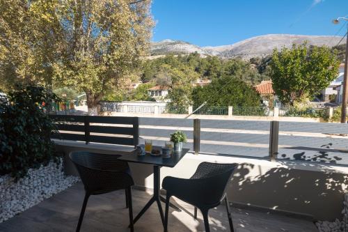 a table and chairs on a balcony with a view of a street at Nicole Studios in Ayia Evfimia