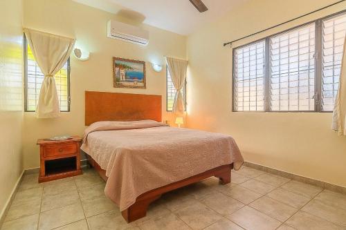 a bedroom with a bed and two windows at D'Piero Hotel in Sosúa